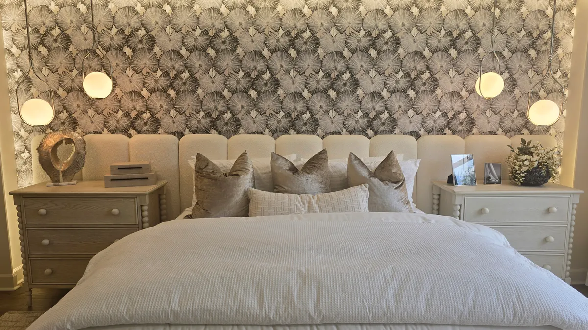 Elegant bedroom with tufted headboard, nightstands, and hanging lights