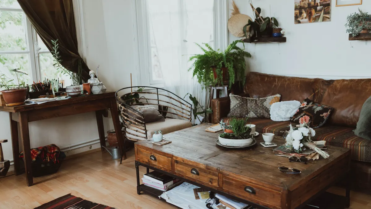 Boho living room with leather sofa, wooden coffee table, chair, and plants