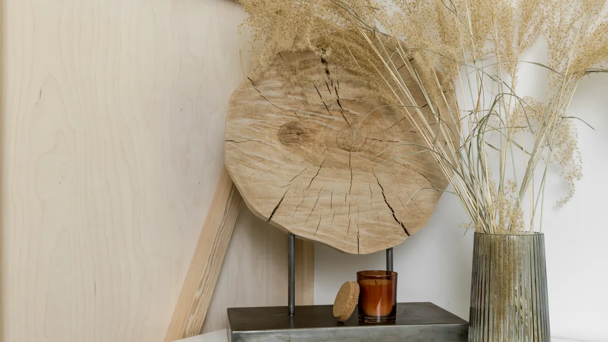 Minimal shelf styling with wood, vase, and dried grasses
