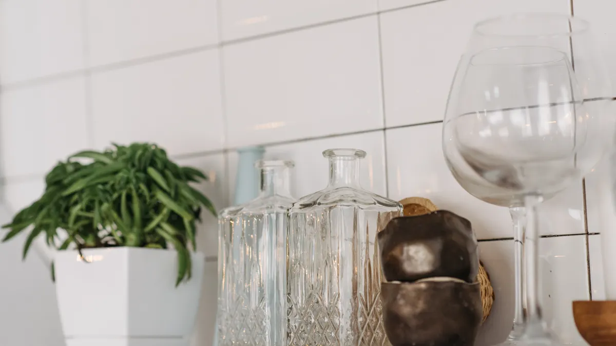 Shelf with plant, glass jars, and decorative glassware